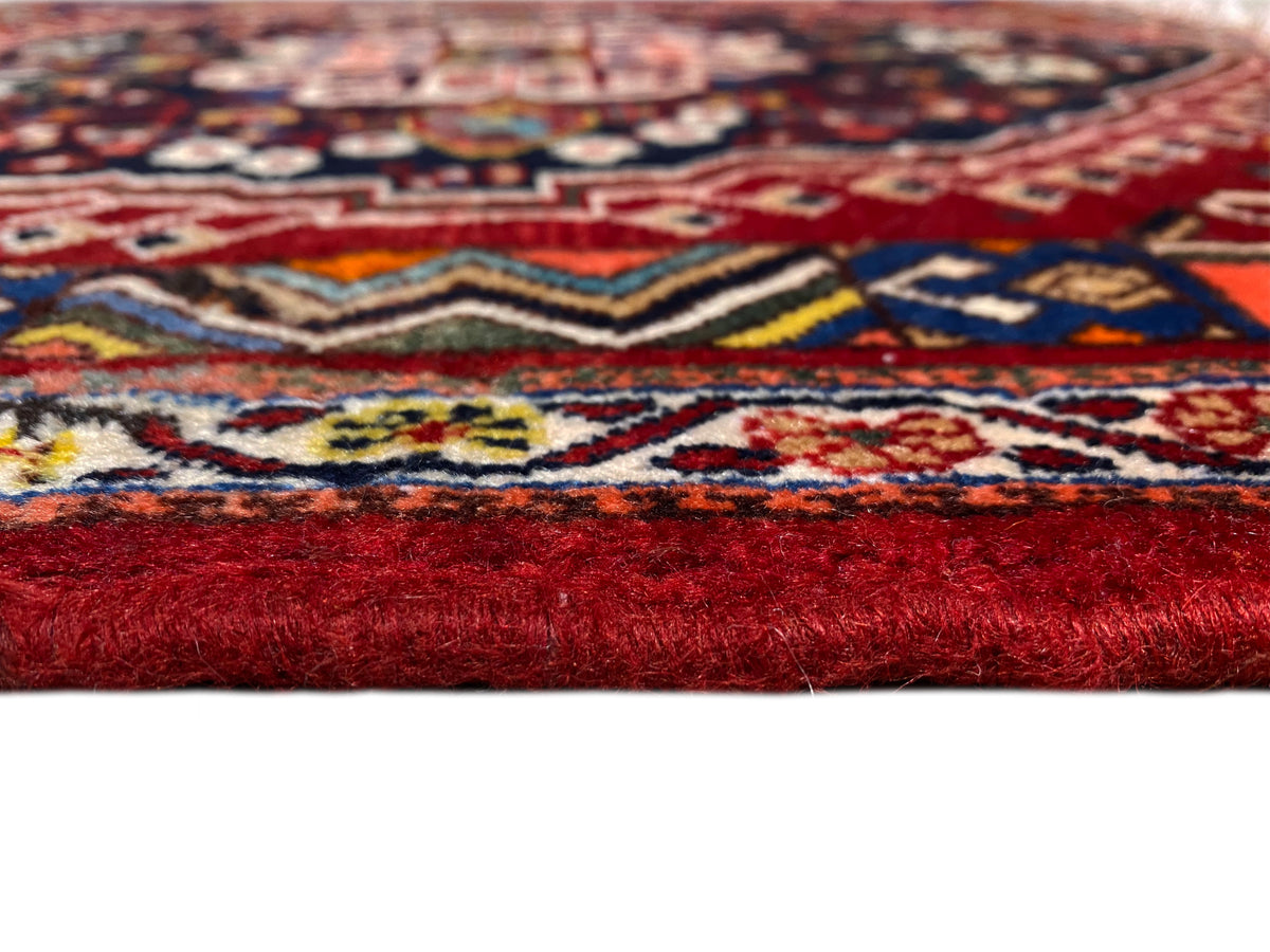 Teppichdetail mit buntem Muster und hoher, roter Florhöhe am Rand