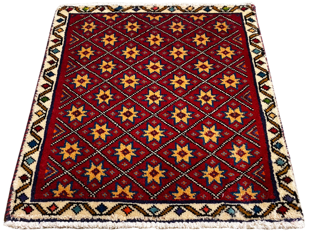 Quadratischer Teppich mit rotem Grund, gold-, blau- und schwarzfarbigen Sternen
