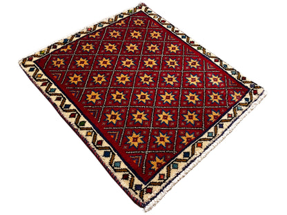 Quadratischer Teppich aufgeschlagen mit rotem geometrischem Muster und buntem Rand