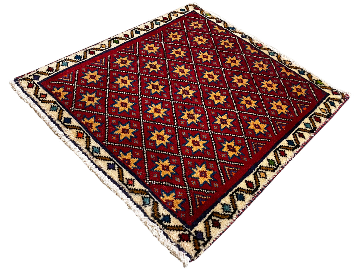Quadratischer Teppich diagonal mit rotem Grund und mehrfarbigen Stern-Quadraten