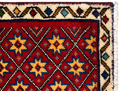 Teppich-Detail am Rand: rotes Sternmuster mit weißem, gemustertem Bordürenrahmen