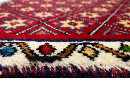 Teppich-Detail: rot-blaues Muster mit Fransen an der unteren Kante